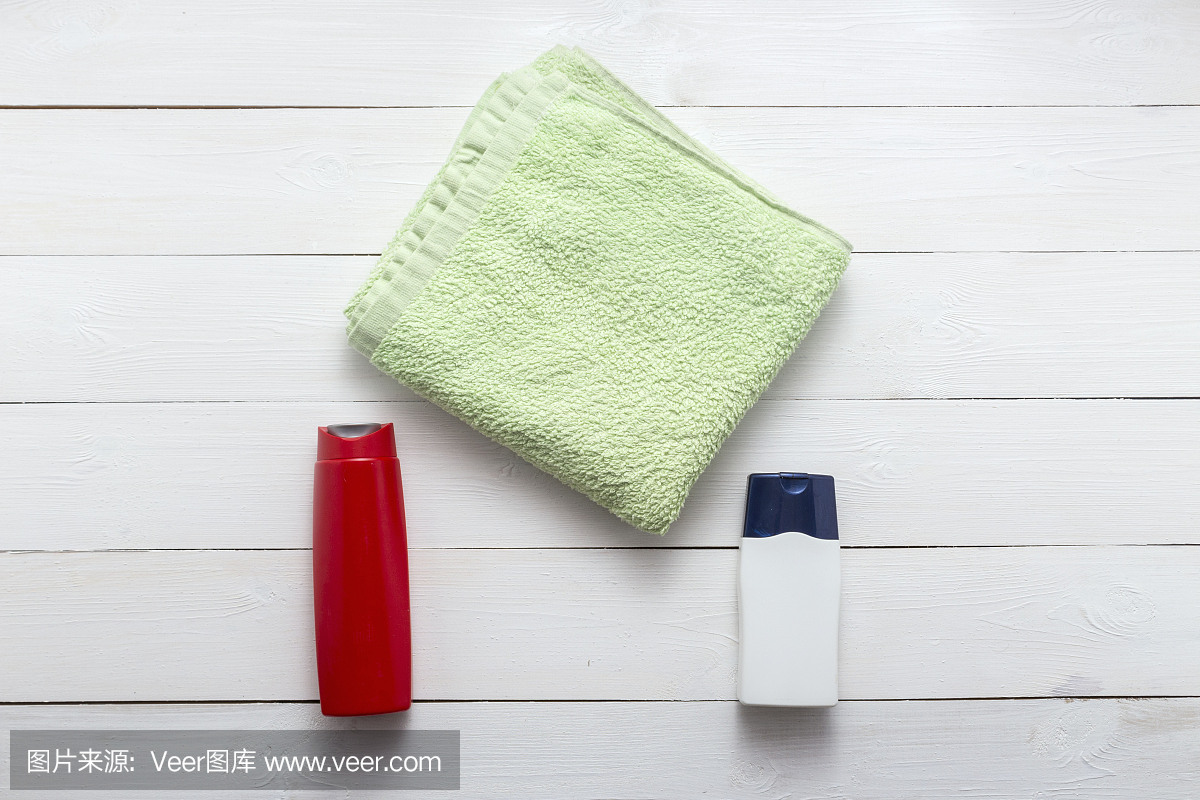 用塑料瓶和毛巾组成的身体护理和美容产品俯视图平铺